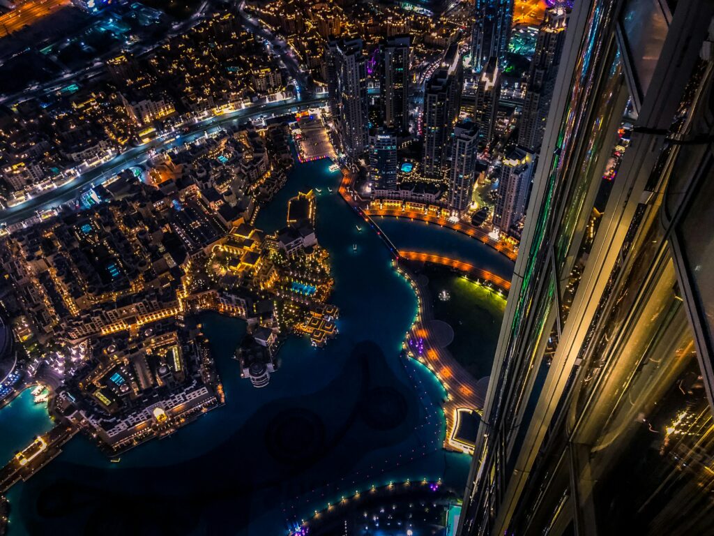 pexels-photo-1467300-1467300 Vibrant aerial cityscape of Dubai at night with illuminated skyscrapers and urban landscape.